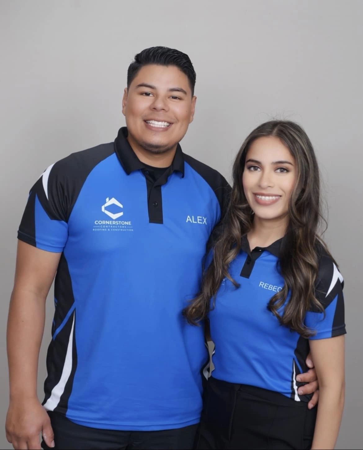 Alex and Rebeca Rodriguez, founders of Cornerstone Roofing & Construction, in matching royal-blue Cornerstone polos