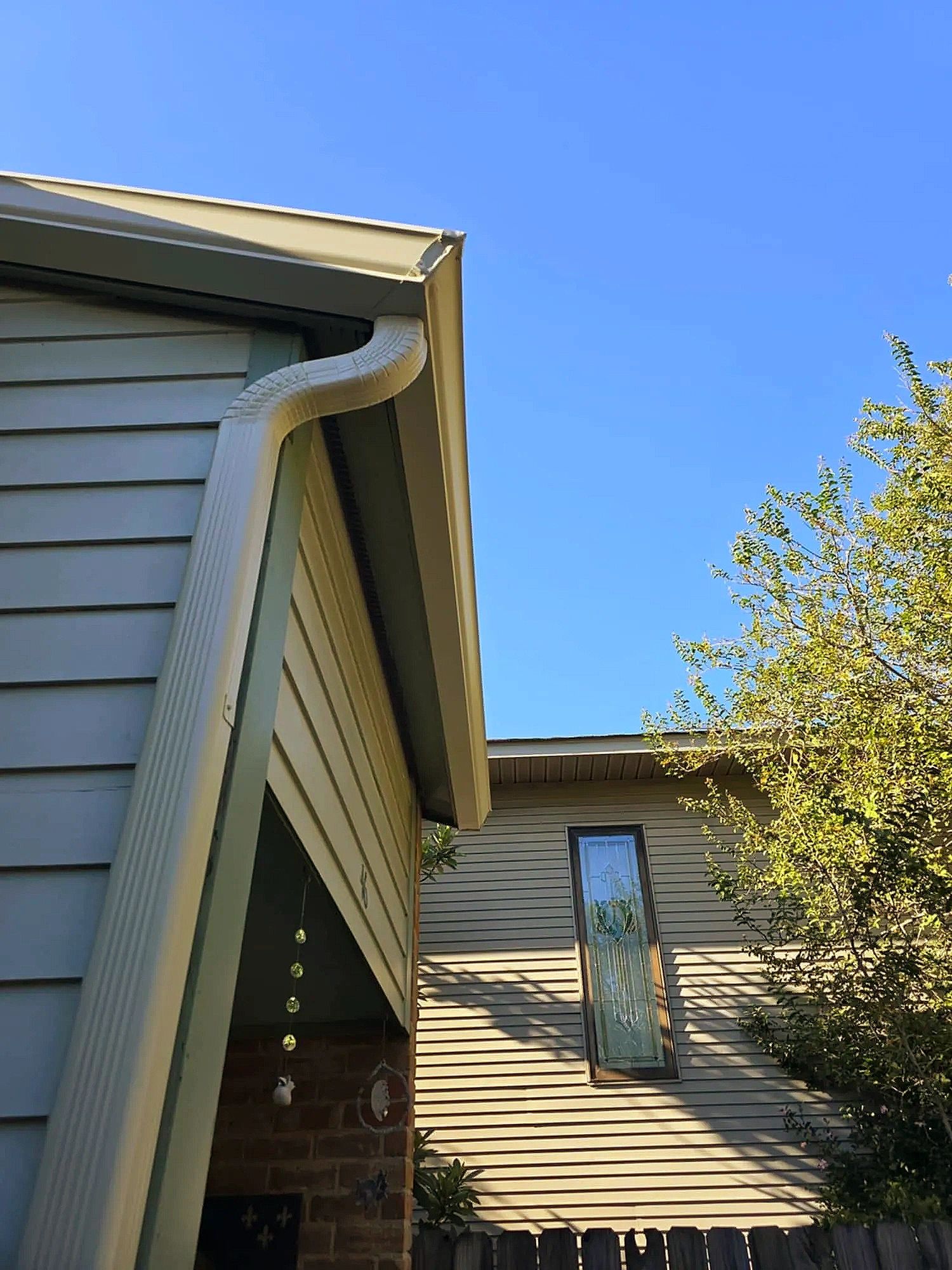 Close-up of a home’s roofline with new shingles, siding and gutter